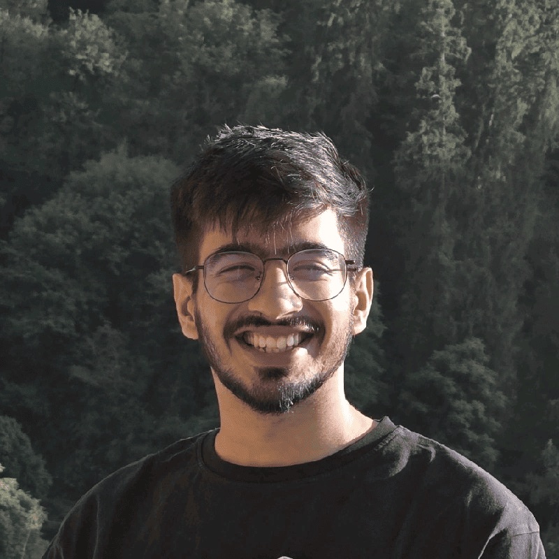 Divyank Nagpal, smiling, in front of trees